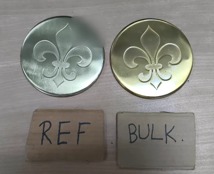 Two embossed brass coasters above REF and BULK cards, showing a difference in plating tone.