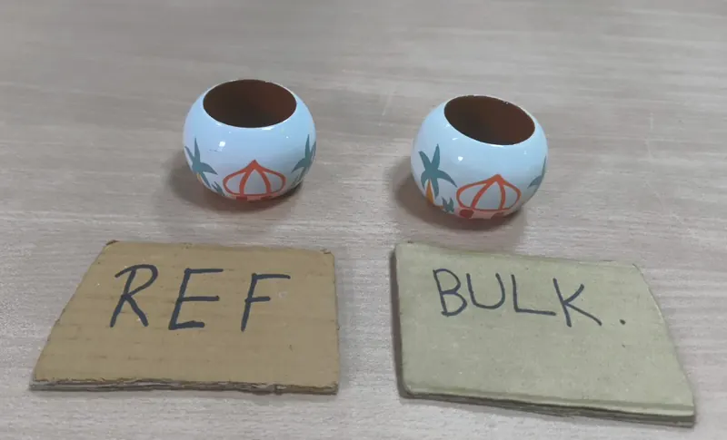 Two hand-painted ceramic napkin rings side by side above handwritten REF and BULK cards.