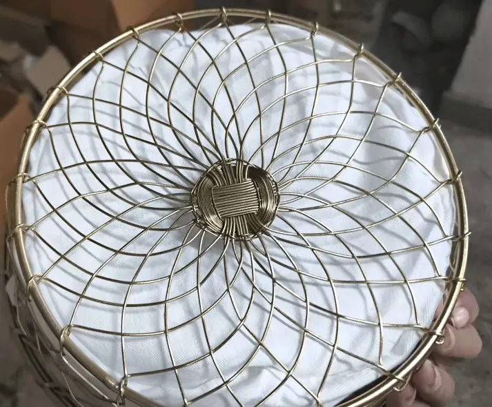 Close-up of the spiral woven brass wire base of a basket with a wrapped centre boss.