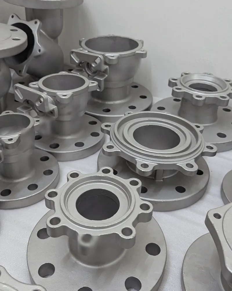 Stainless steel flanged valve bodies laid out on a white sheet, ready for inspection.